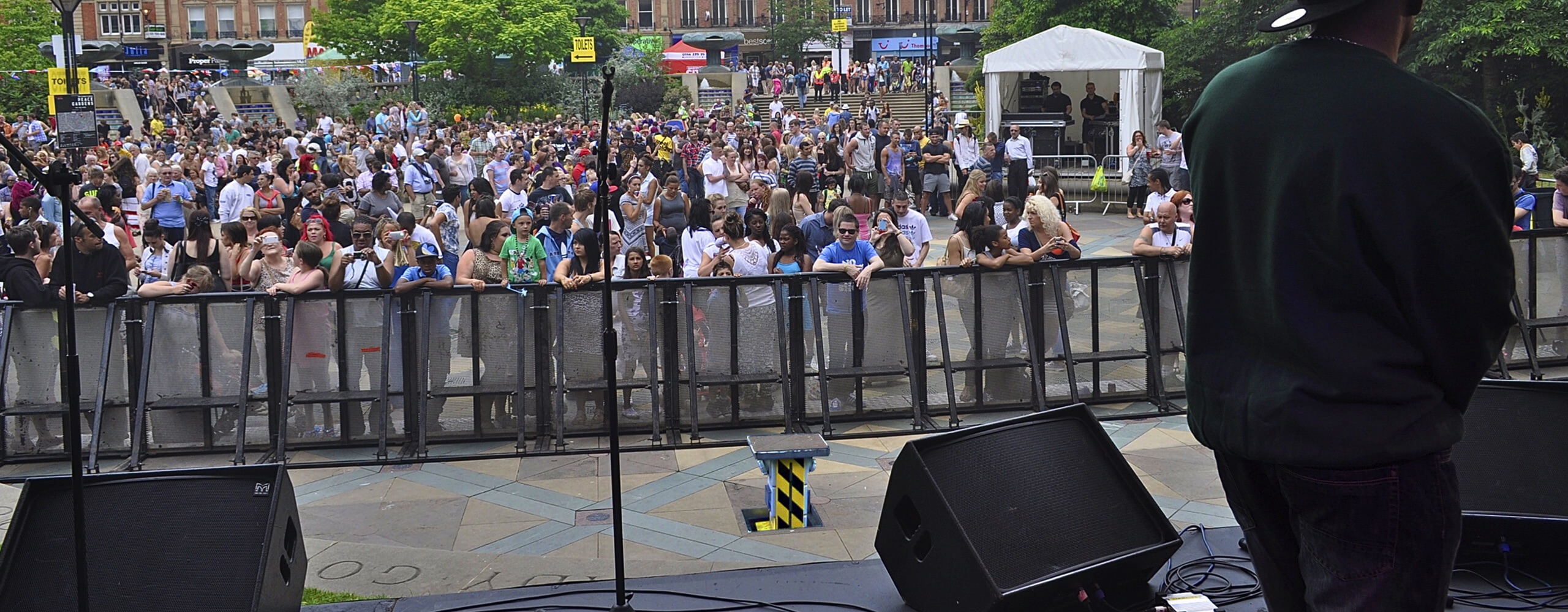Image showing a view from a stage looking out across crowds with a pop up power unit in front of crowd barriers